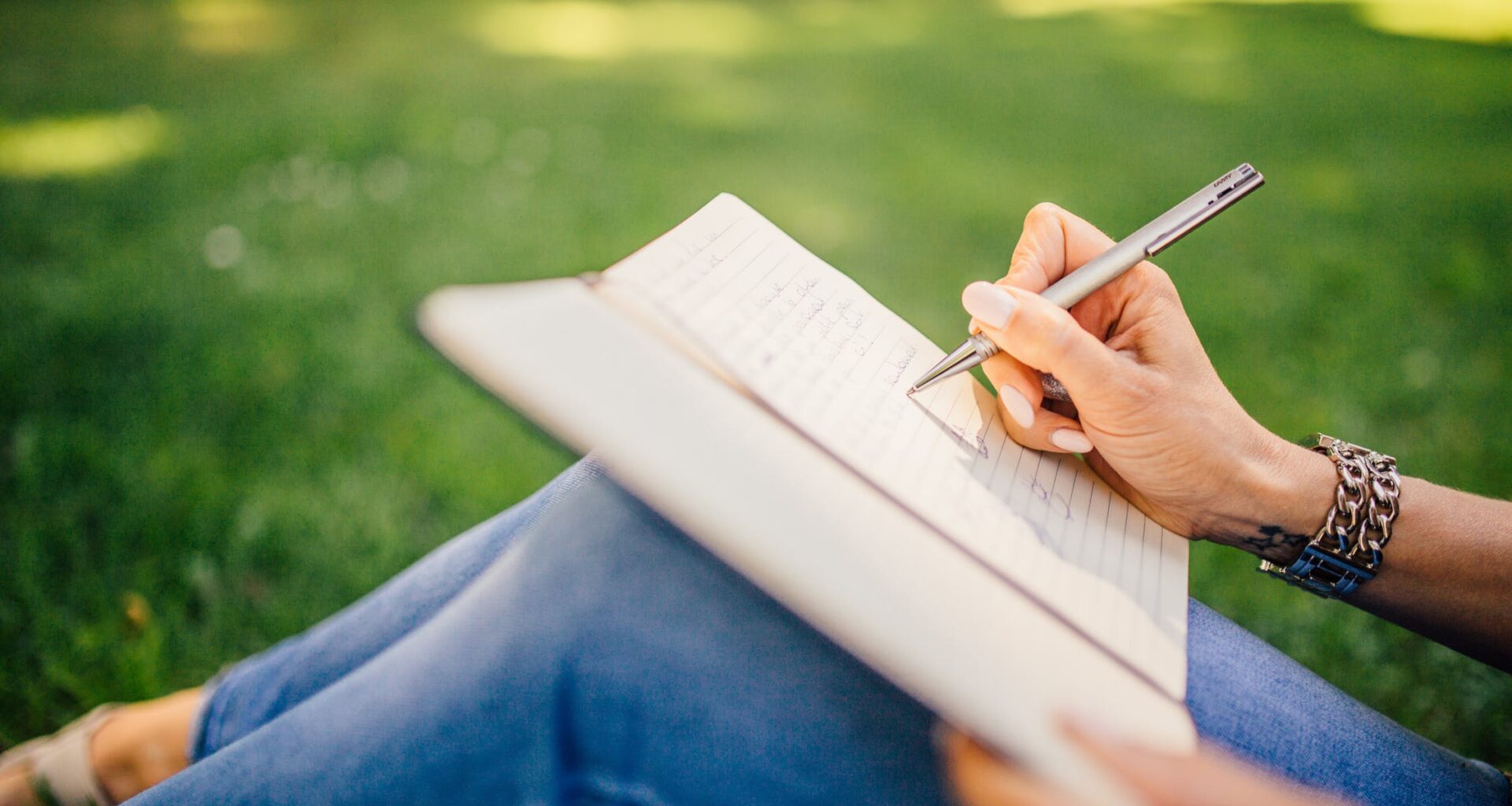 Photo of a woman writing on a Notebook