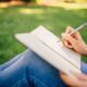 Photo of a woman writing on a Notebook