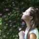 Woman outside smelling flowers